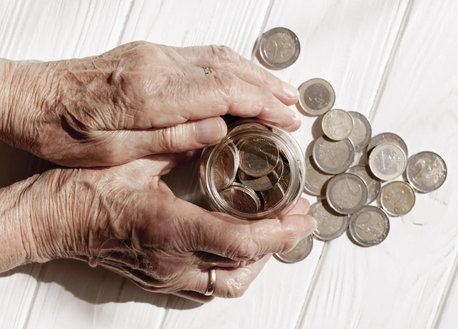 Elder person holding a jar with coins