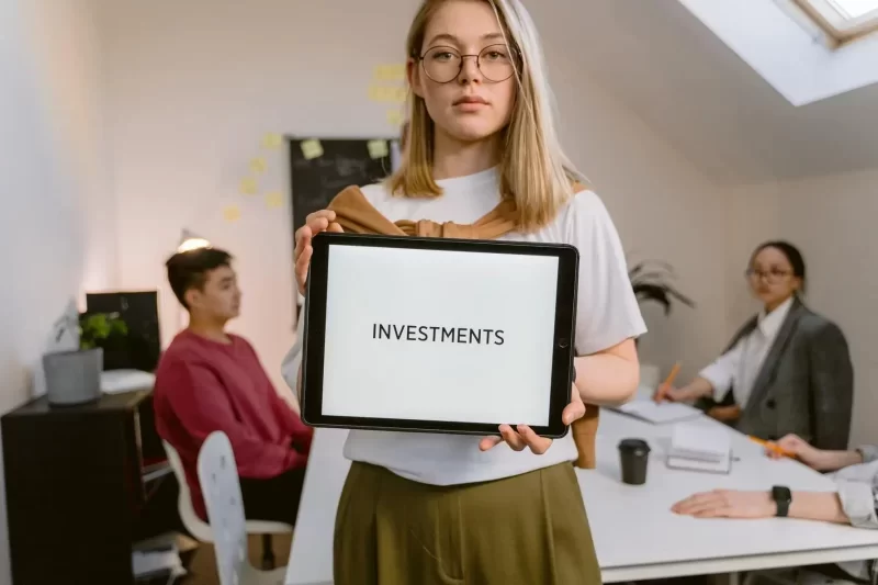 Person holding a sign with the word investments